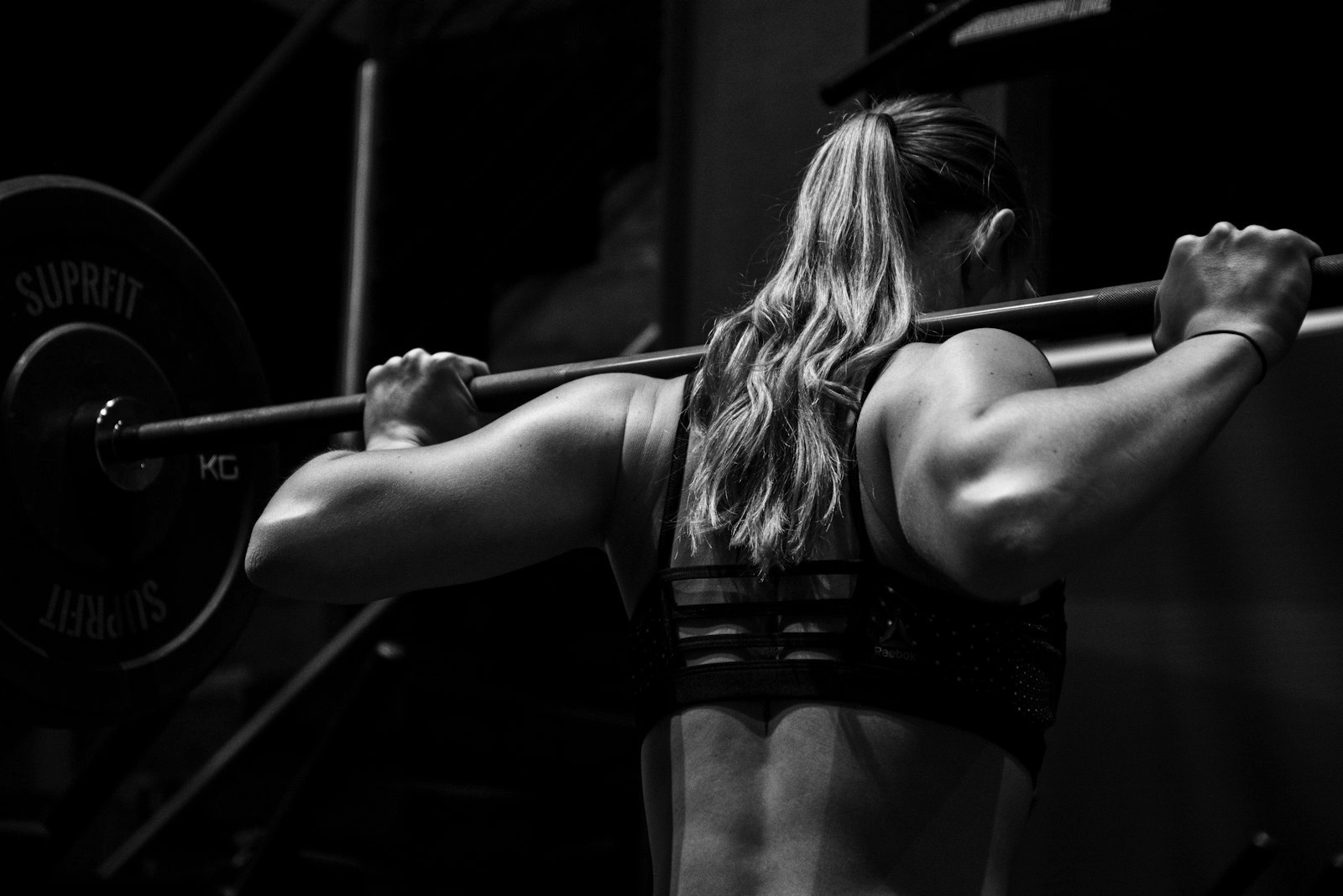 Athlète en squat barre sur le plateau